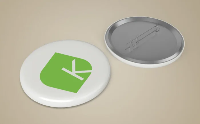 Broche personnalisée avec logo vert moderne conçue par Comhit, agence de branding à Paris.
