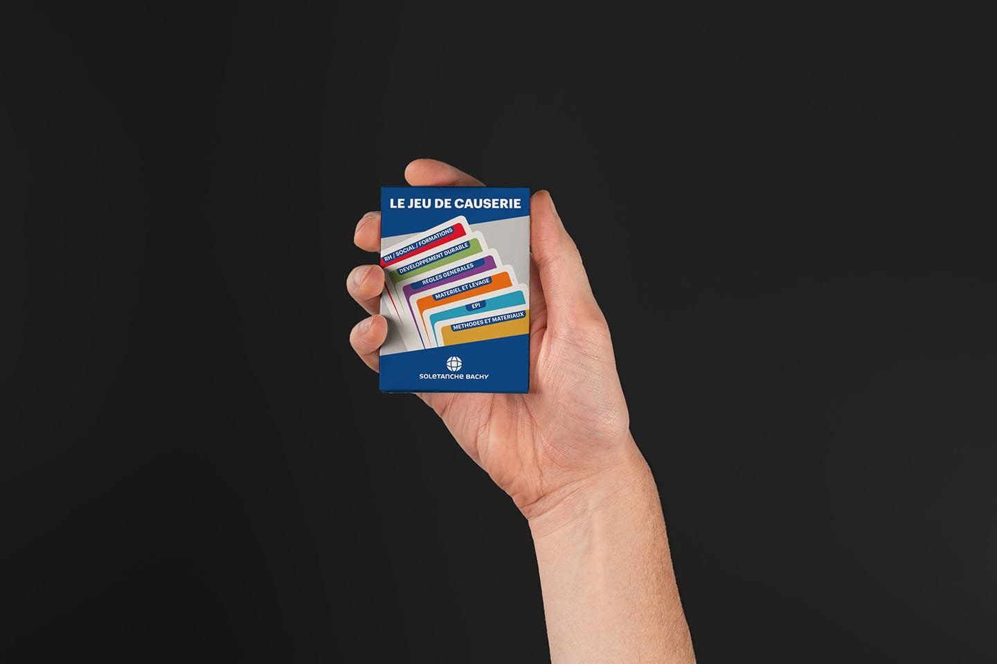 Hand holding a colourful pack of cards, modern design by the Comhit agency to reinforce visual communication.