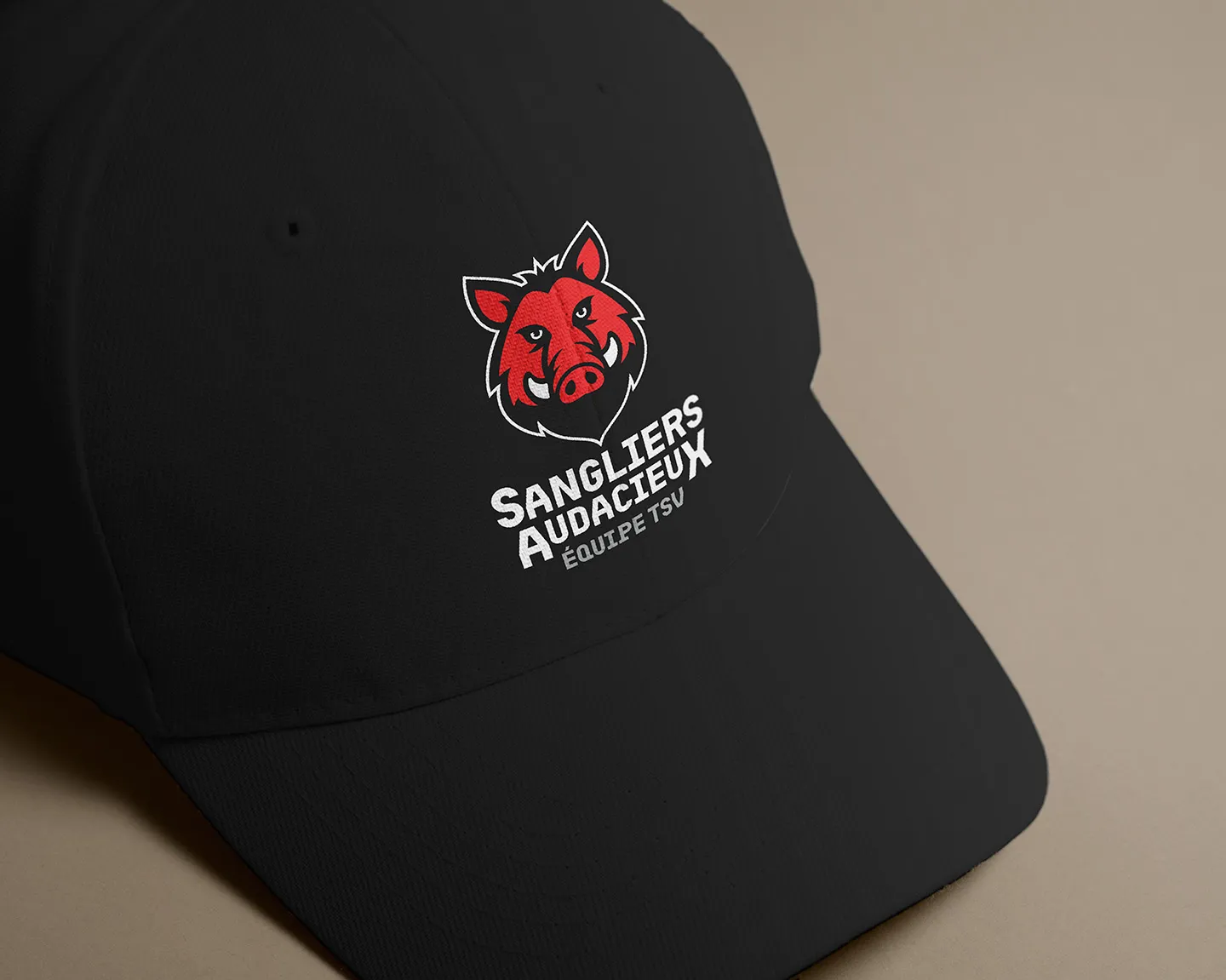 Black cap with red boar logo by Comhit, a branding agency in Paris, for the Sangliers Audacieux team.