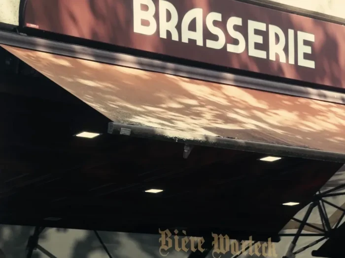 Una marquesina para una brasserie de París diseñada por Comhit, que ilustra una identidad visual elegante para un entorno urbano.