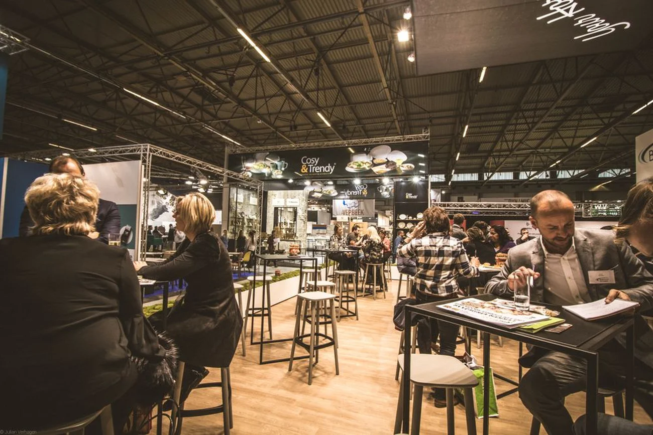 Salon professionnel avec stands, visiteurs et supports de communication